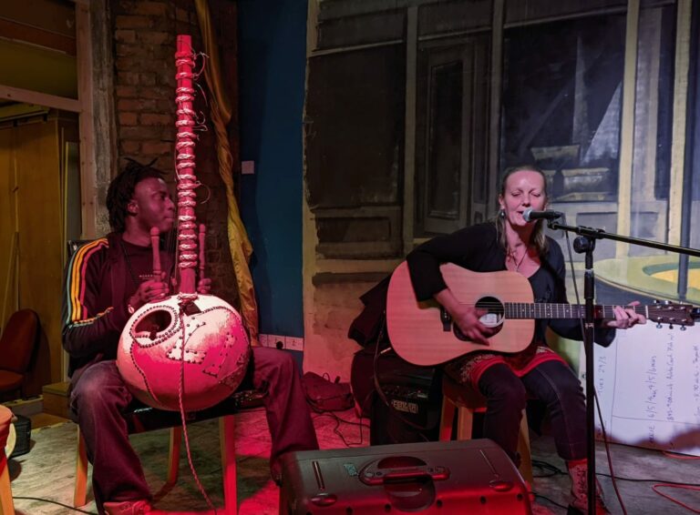 Two musicians playing guitar and African Kora