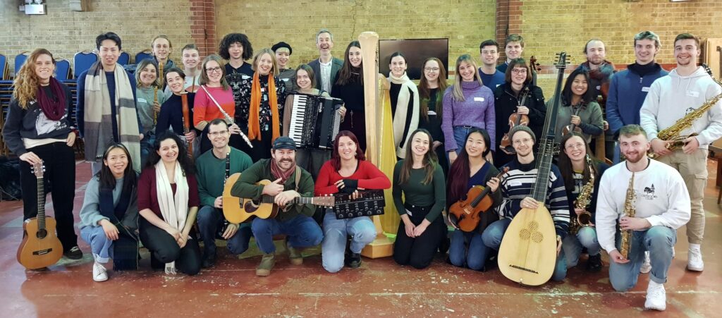 A group of musicians holding instruments posing for a photo